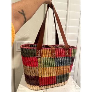 Handwoven tote, straw and leather straps.